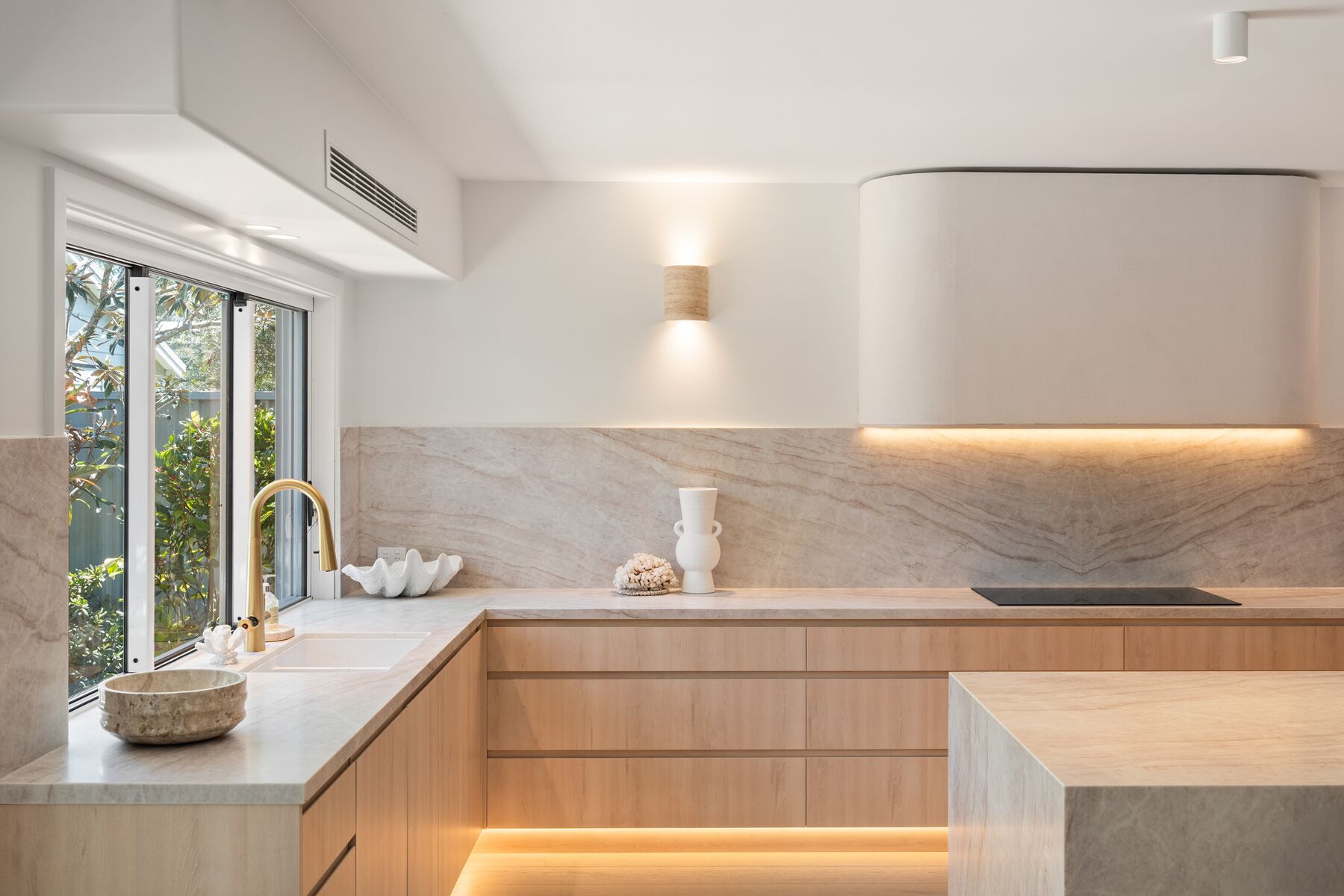 Kitchen sink run with timber joinery, wall light and LED kickboard lighting