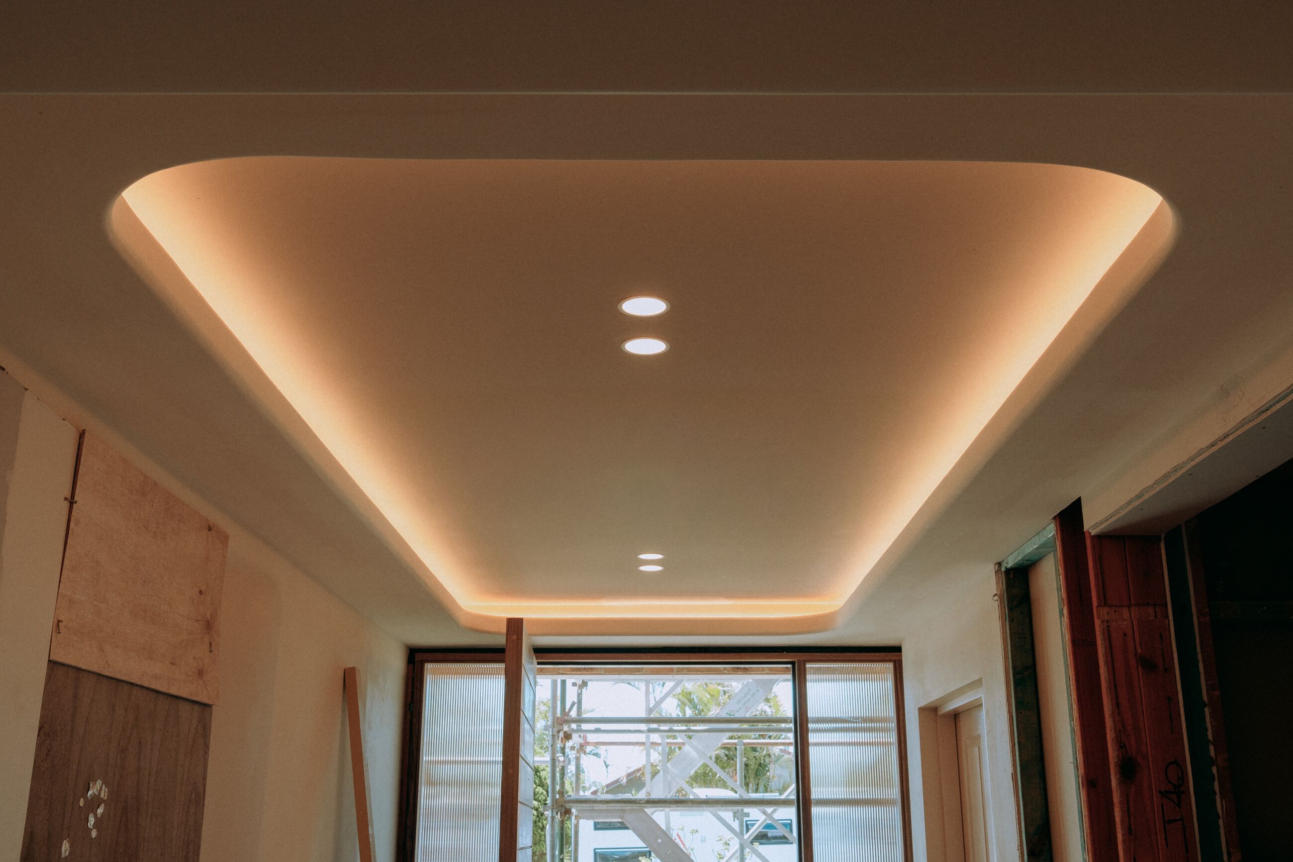 Hallway with a recessed ceiling cove, concealed LED strip and downlights