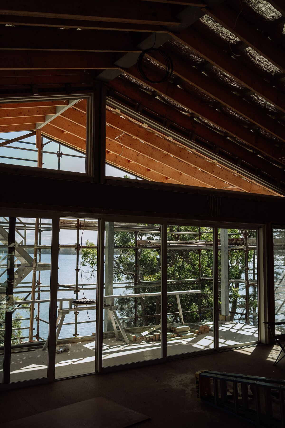 Exposed raked roof framing during a renovation, with scaffolding outside