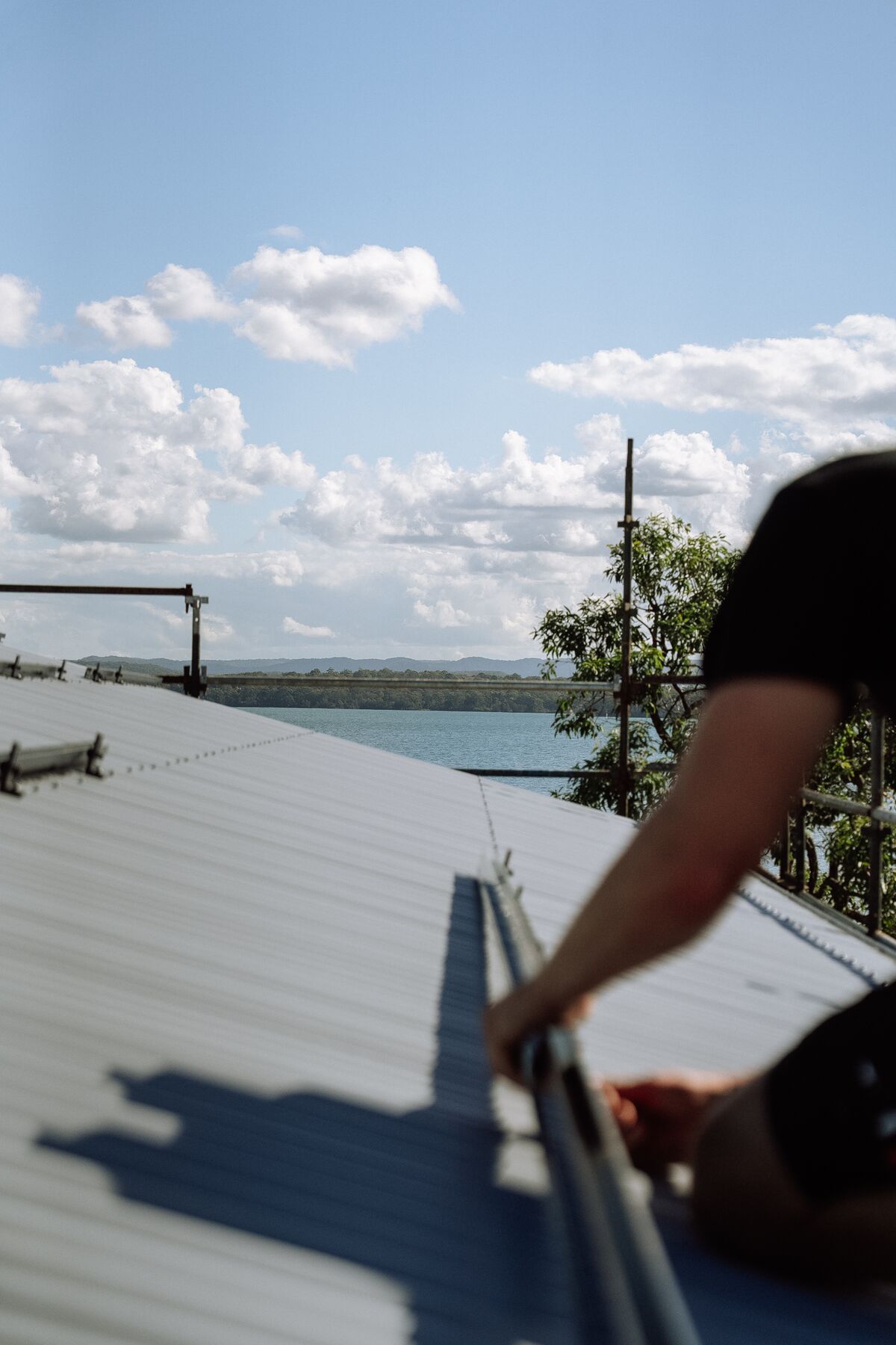 Fusion installer in a branded shirt walking across a metal roof