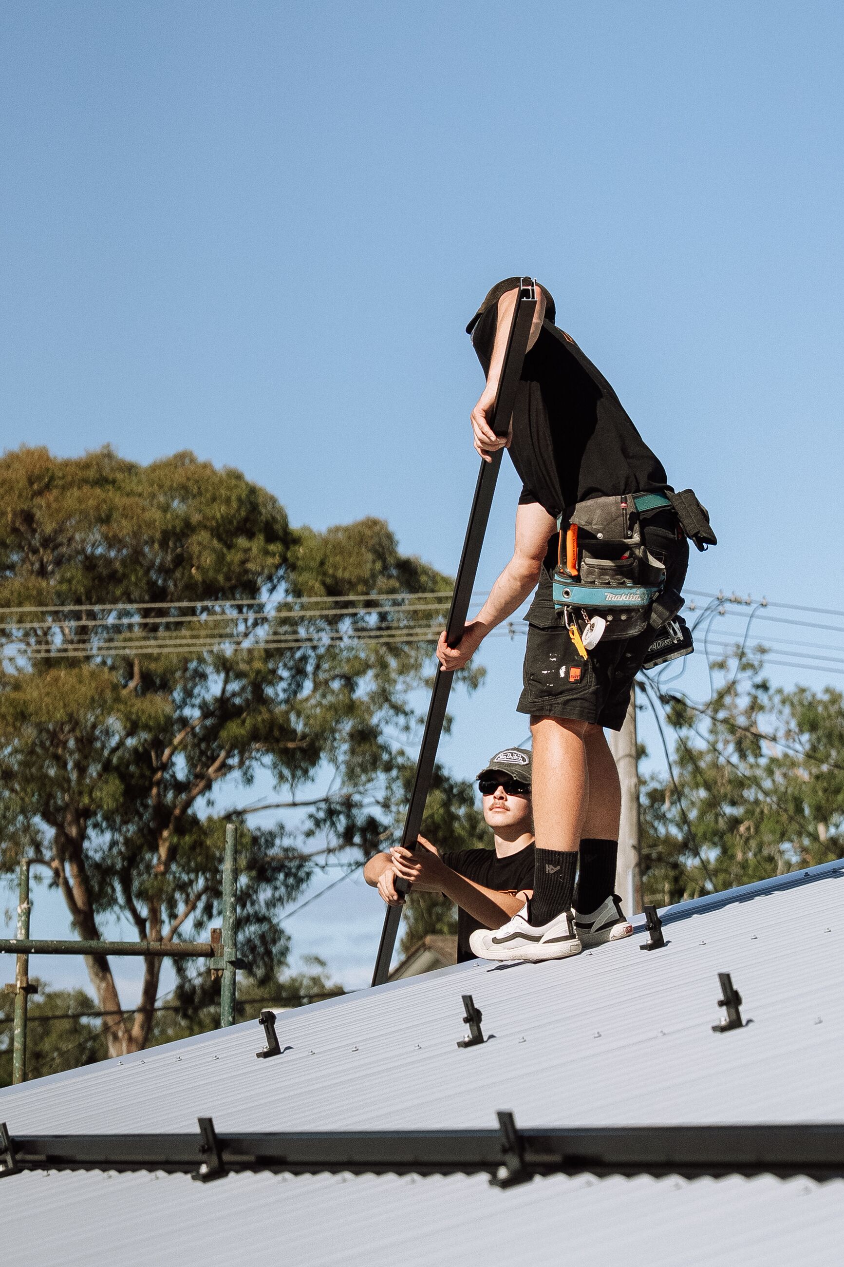 Fusion installers working on a metal roof during a solar installation