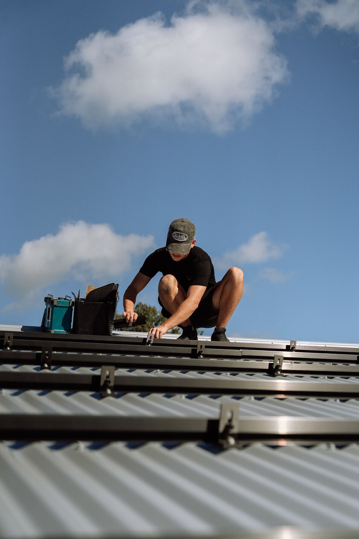 Fusion installers working on a metal roof during a solar installation